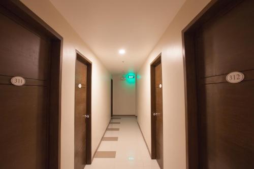 a hallway with two doors and a green light at Emerald Suites CDO in Cagayan de Oro