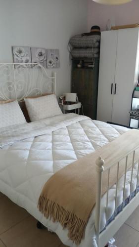 a bedroom with a large white bed with white sheets at Christi & Paris Nest in Volos