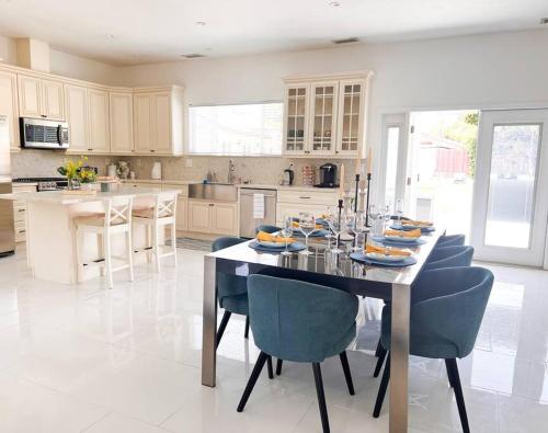 a kitchen with a table with blue chairs and a tableasteryasteryasteryasteryastery at Luxury Oasis in Central Encino w Pool & Spa Topeka in Los Angeles