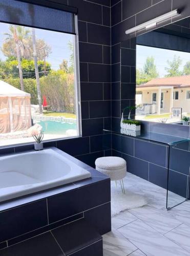 a blue bathroom with a tub and a window at Luxury Oasis in Central Encino w Pool & Spa Topeka in Los Angeles