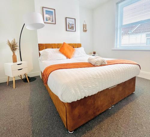 a bedroom with a large bed with orange pillows at Hudson Road in Portsmouth