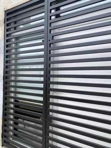 a black metal garage door with a window at Summer Haven MaR dEl PlAtA in Mar del Plata