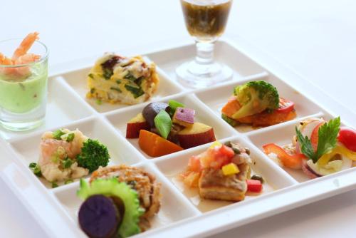 a plate of food on a table with a glass of wine at Hotel Hakuba in Hakuba
