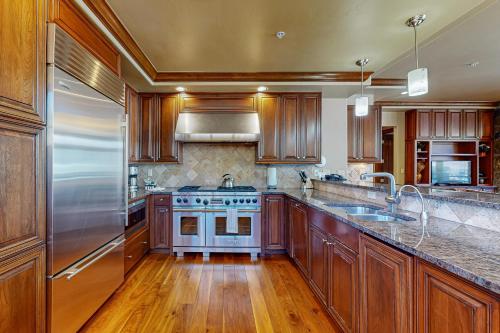 a kitchen with wooden cabinets and a stainless steel refrigerator at Lion Square Lodge Tower T401 in Vail