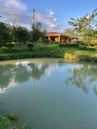 a house with a pond in front of a house at El Ensueño Ecohostal & Glamping in Mocoa