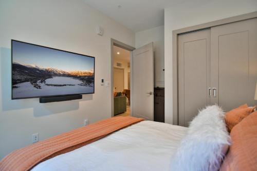 a bedroom with a flat screen tv on the wall at Skywalk Flats Amphitheater Retreat: Downtown, Hot Tubs in Silverthorne