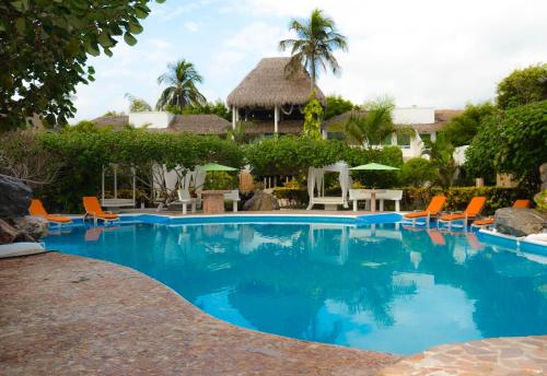 a pool at a resort with chairs and umbrellas at Bon Jesus Hotel in Costa Esmeralda