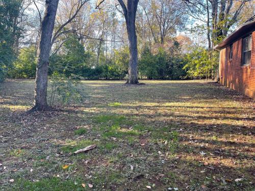 a yard with two trees and a brick building at Brick Point Place- 10 Min N of UAH in Huntsville