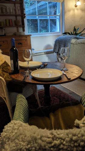 a table with two glasses and a bottle of wine at The Hideaway in Falmouth