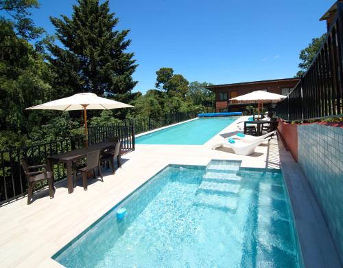 a swimming pool with a table and an umbrella at Mirabosque aparment Ejecutivos 8 in Osorno