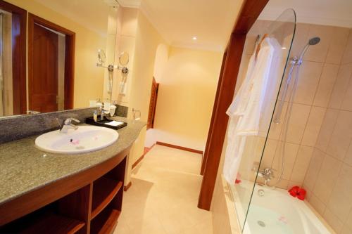 a bathroom with a sink and a shower and a tub at Jalsa Beach Hotel & Spa in Poste Lafayette