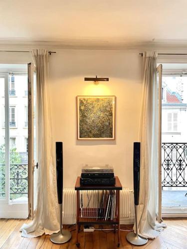 - un salon avec une table et deux haut-parleurs dans l'établissement ParisHome! Double Balcony, Art & Designer Touches, à Paris