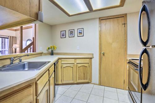 a kitchen with a sink and a refrigerator at Mountainside Royalview Condo: Pool/Hot Tubs, Great Location in Frisco