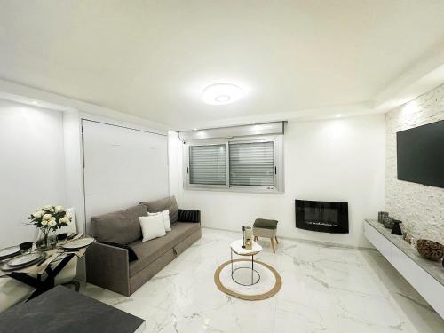 a living room with a couch and a tv at Studio 36mt2 a 5 min a pied boulevard de Belgique MC in Beausoleil