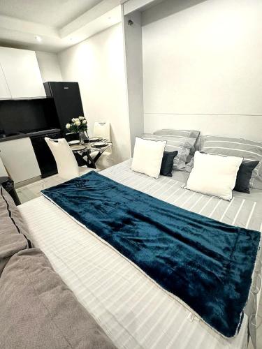 - un grand lit avec une couverture bleue dans l'établissement Studio 36mt2 a 5 min a pied boulevard de Belgique MC, à Beausoleil