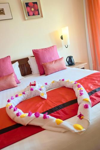a heart made out of flowers on a bed at Jalsa Beach Hotel & Spa in Poste Lafayette