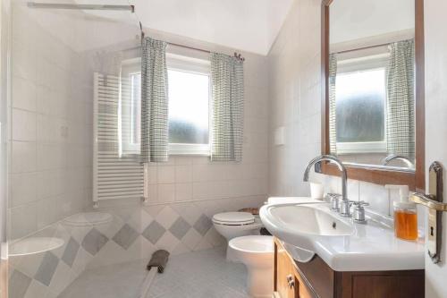 a white bathroom with a sink and a toilet at Casa Kanustera in Ischia