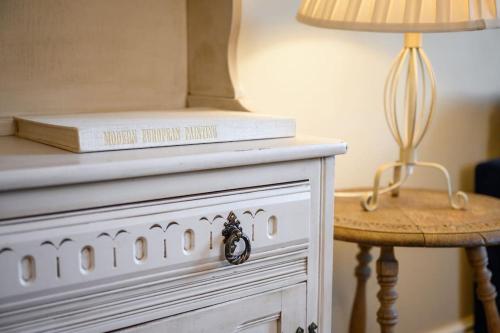 a book sitting on top of a dresser next to a lamp at Charming Luxury Apartment Peak District in Matlock