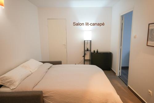 une chambre avec un lit et un panneau sur le mur dans l'établissement Appartement confortable et lumineux à Belleville, à Paris