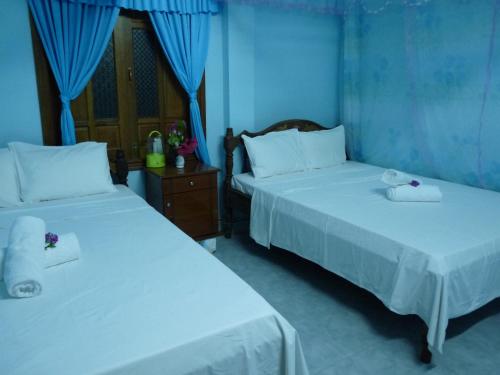 two beds in a room with blue walls at Cham Island Smiles Homestay in Tân Hiệp