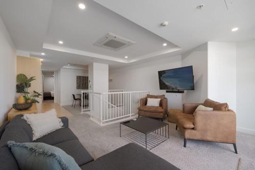 a living room with a couch and two chairs at Ocean Eleven Mt Maunganui in Mount Maunganui
