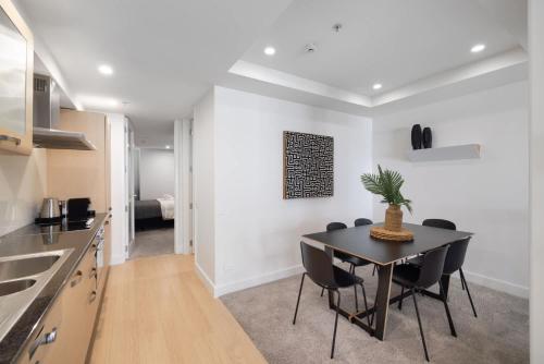 a kitchen and dining room with a table and chairs at Ocean Eleven Mt Maunganui in Mount Maunganui