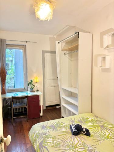 une chambre avec un lit, un bureau et une fenêtre dans l'établissement Chambre Berce, à Toulouse