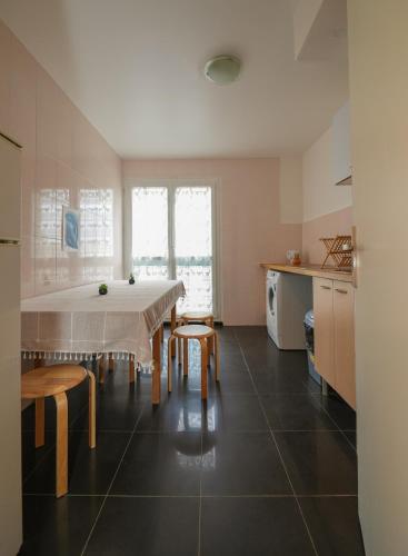 une cuisine avec une table et des chaises dans une pièce dans l'établissement Appartement confortable et lumineux à Belleville, à Paris
