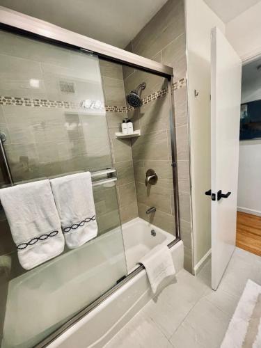 a bathroom with a shower and a bath tub with towels at Nicely Furnished 2BR Menlo Park Apartment in Menlo Park