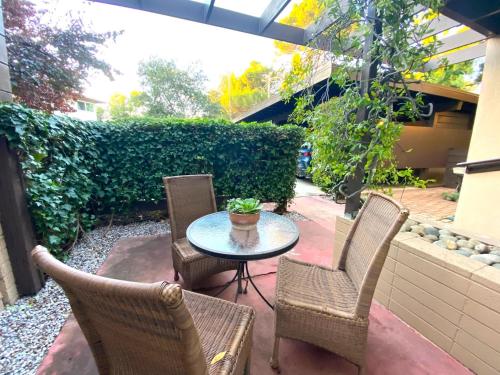 a patio with three chairs and a table with a potted plant at Nicely Furnished 2BR Menlo Park Apartment in Menlo Park