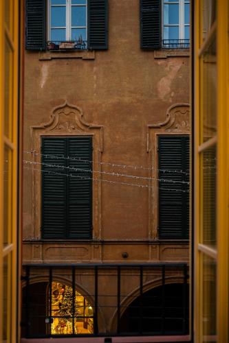 a building with two windows and a fence in front at Casa del Cinema in Modena