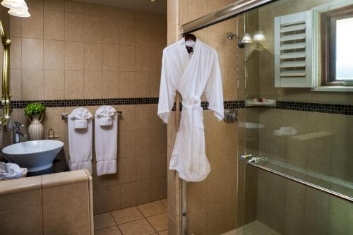 a bathroom with a robe hanging on the shower at The Eagle Inn in Santa Barbara