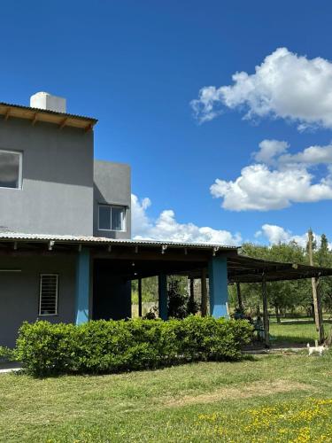 a house with a dog sitting in front of it at Casaquinta Sunrise La Plata in Abasto