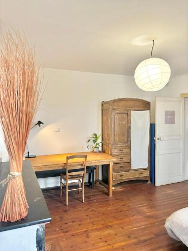 d'une salle à manger avec une table en bois et un réfrigérateur. dans l'établissement Chambre Bugrane, à Toulouse