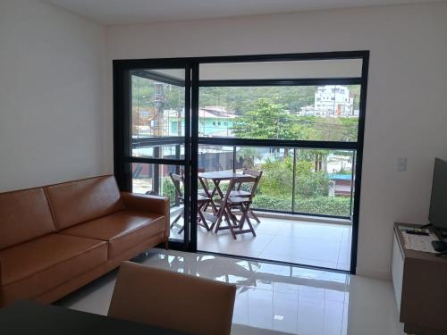 a living room with a couch and a table with a view at Recanto Aguapés in Governador Celso Ramos