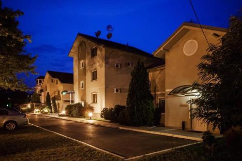 a house with a car parked in a parking lot at night at Cozy Villa withy yard and private parking in Belgrade