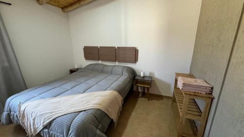 a small bedroom with a bed and a side table at Alquiler Centro SAN RAFAEL in San Rafael