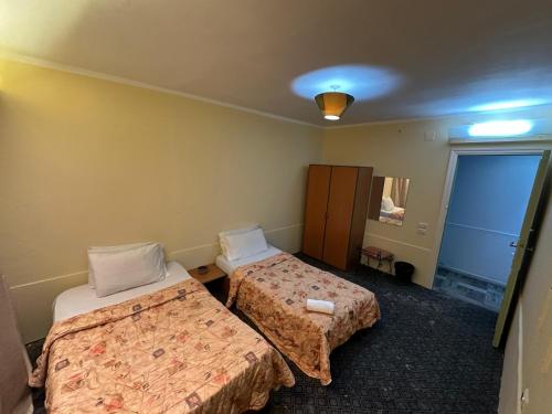 a hotel room with two beds and a mirror at Arabesque Hotel in Cairo
