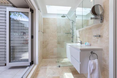 une salle de bain avec une douche, un lavabo et un miroir dans l'établissement 56 Becker Road, à Forster