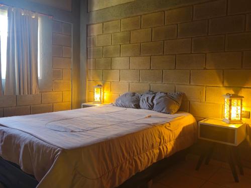 a bedroom with a bed with two lights on it at CABAÑA DORADA in Villa Ciudad de América