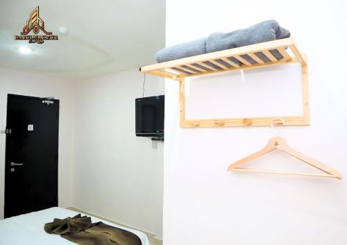 a room with a bed and a shelf on the wall at DarulMakmur Scout Lodge in Kuantan