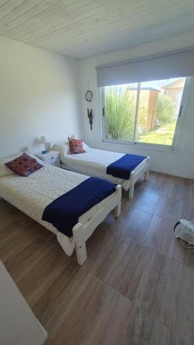 a bedroom with two beds and a large window at Casa en Chapa in La Estafeta