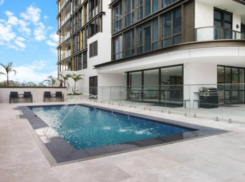 a swimming pool in front of a building at Modern 2BR with City Views & Pool Near Parramatta in Sydney