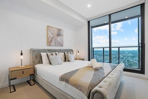 Ένα ή περισσότερα κρεβάτια σε δωμάτιο στο Modern 2BR with City Views & Pool Near Parramatta