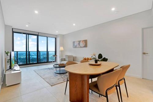 a dining room and living room with a table and chairs at Modern 2BR with City Views & Pool Near Parramatta in Sydney