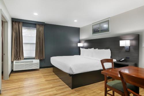 a bedroom with a bed and a desk and a table at Best Western Mystic Hotel in Mystic