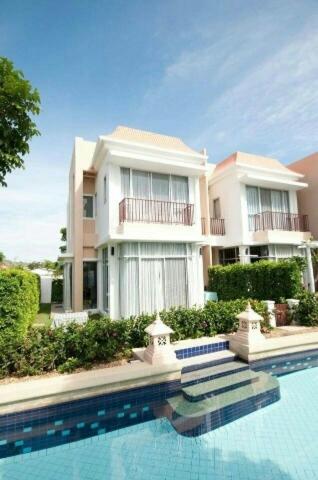 a building with a swimming pool in front of it at Teddy Bear Villa Hua Hin in Cha Am