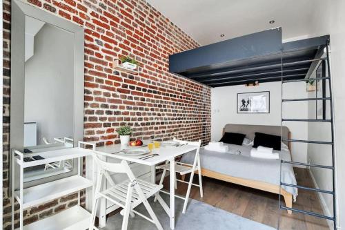 Cette chambre comprend une mezzanine, une table et des chaises. dans l'établissement Studio paisible Paris 10ème - Canal St Martin, à Paris