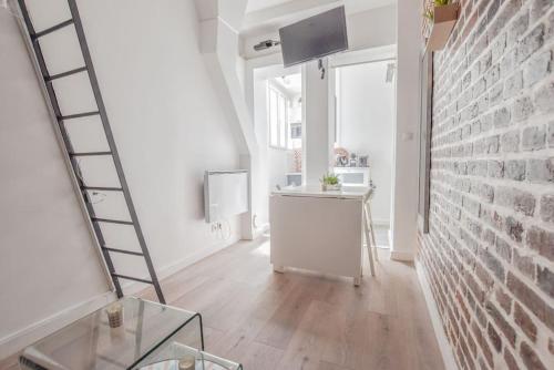 - un escalier dans une chambre blanche avec une table en verre dans l'établissement Studio paisible Paris 10ème - Canal St Martin, à Paris