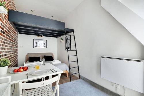 une chambre avec un lit et une table avec des fruits dessus dans l'établissement Studio paisible Paris 10ème - Canal St Martin, à Paris